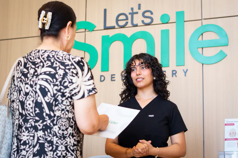A patient receives her written treatment plan at the Let’s Smile Dentistry front desk in Mexicali